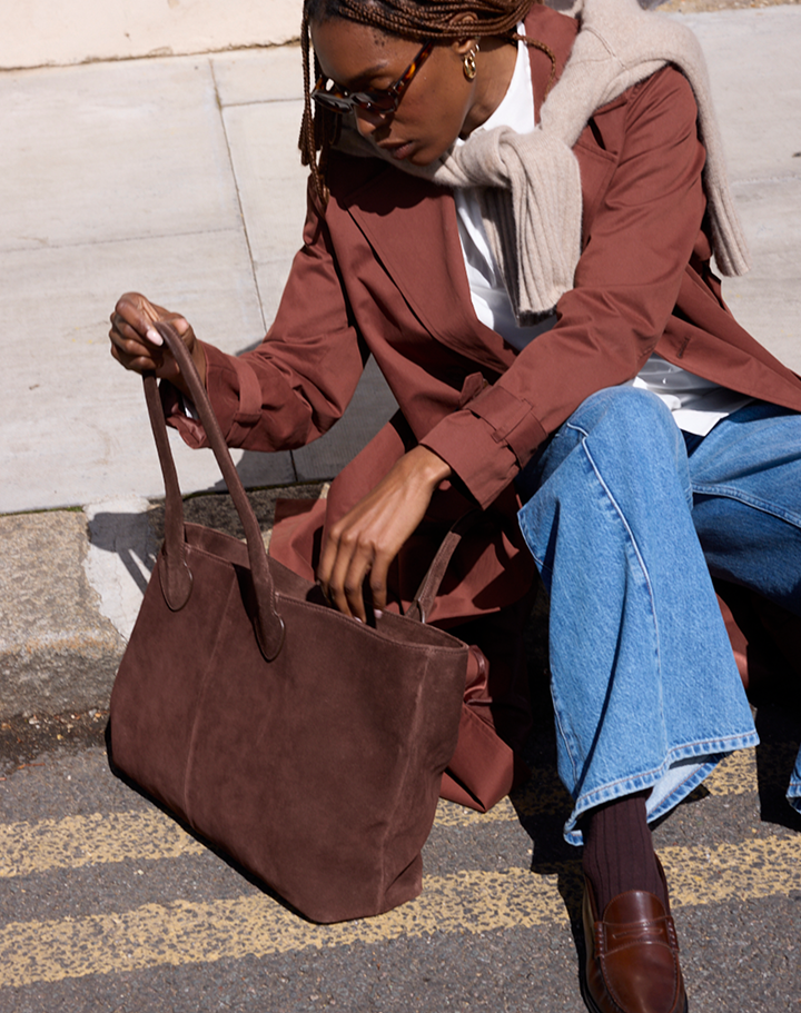Model carrying a brown suede tote bag