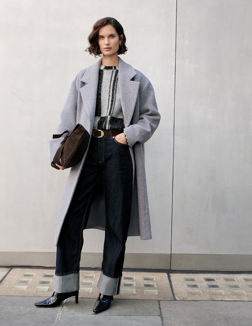 woman waerring dark denim jeans and a grey coat