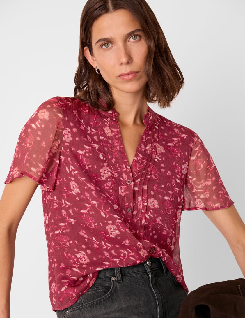 Woman wearing a short sleeve burgundy printed blouse for Whistles 25% off everything labor day promotion