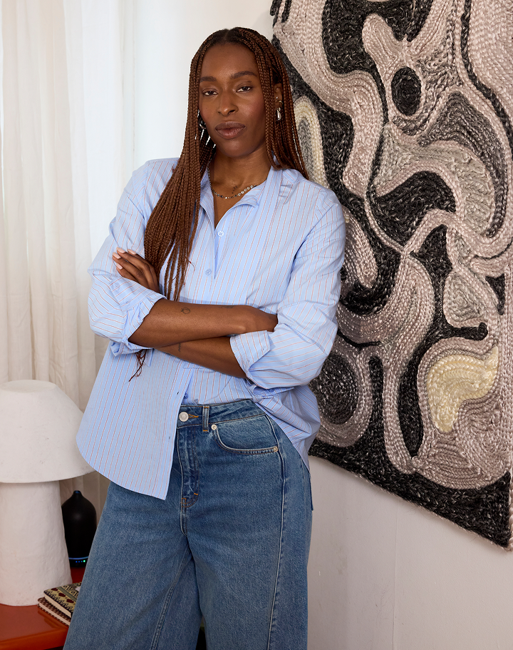 Model wearing a blue striped long sleeve shirt with jeans