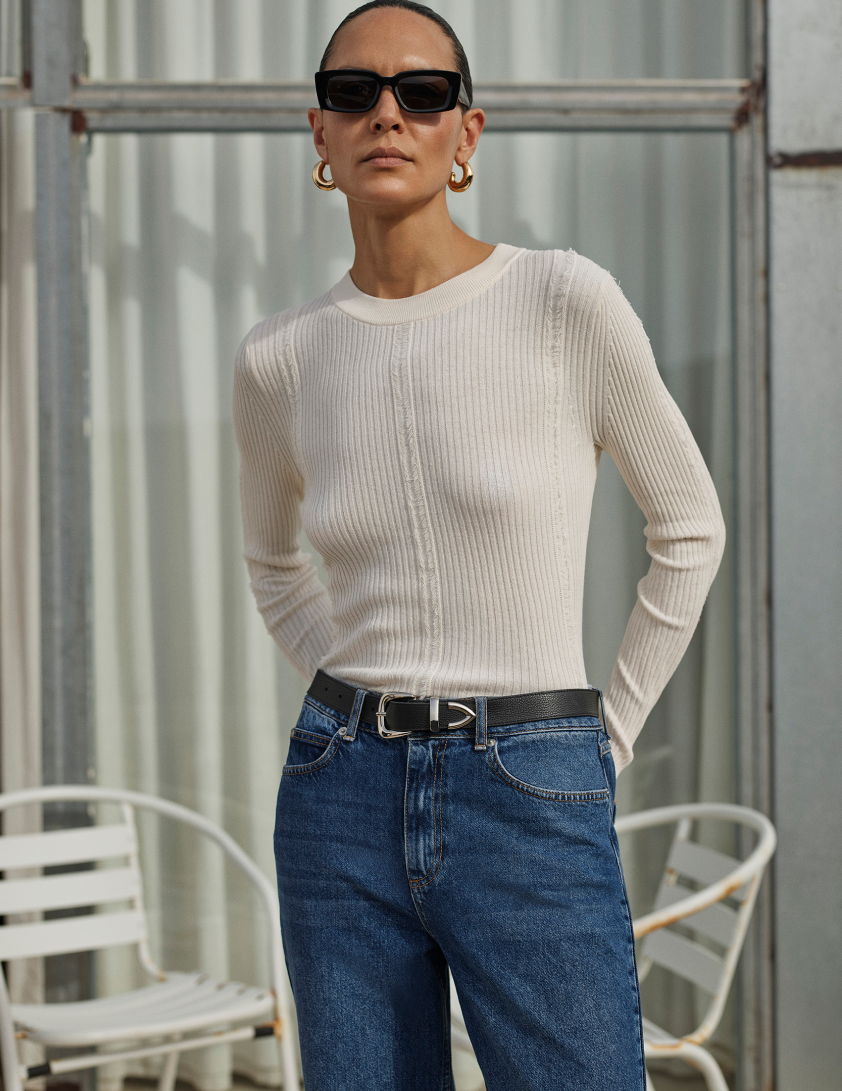 Woman wearing white long sleeve top and jeans